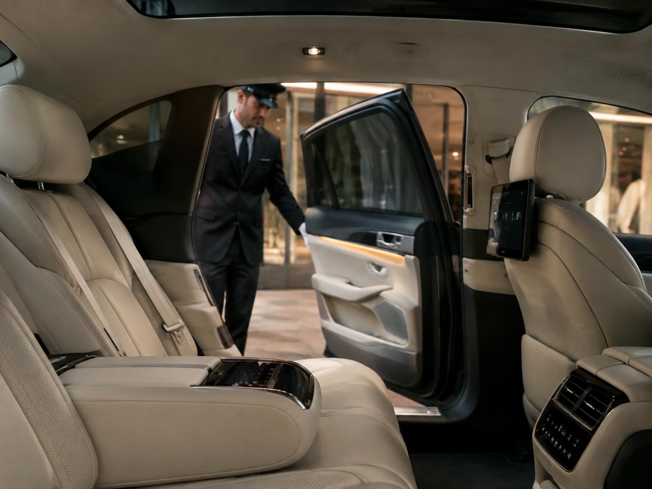 Quiet electric cabin with a uniformed chauffeur opening the door
